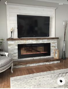 a flat screen tv mounted above a fireplace in a living room