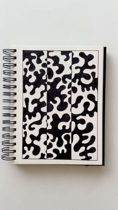 a spiral notebook with black and white animal print