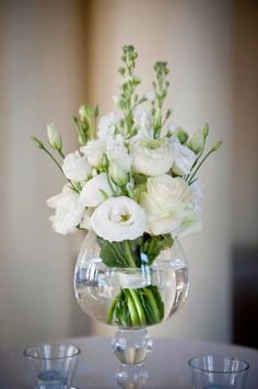 a vase filled with white flowers on top of a table