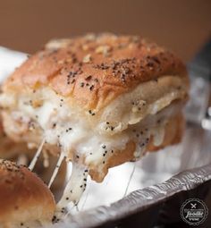 two pieces of bread covered in cheese and sprinkled with black sesame seeds on a silver tray