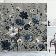 a shower curtain with blue and white flowers on it in front of a bath tub