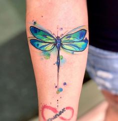 a woman's leg with a tattoo on it that has a dragonfly painted on it