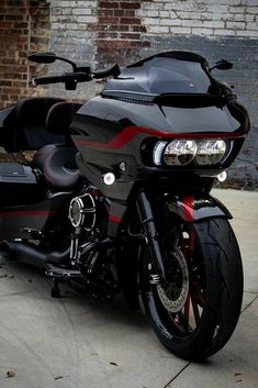 a black and red motorcycle parked in front of a brick building