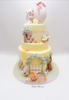 a three tiered cake decorated with animals and flowers