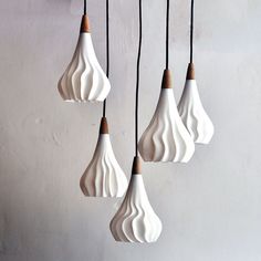 five white and brown hanging lights on a wall