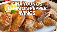 a white plate topped with chicken wings covered in lemon