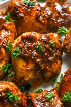 chicken wings with sauce and parsley on a white plate