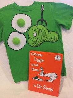 a green t - shirt and book on a bed