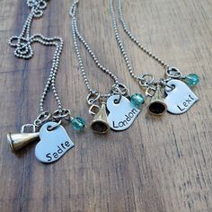 three necklaces with charms that say sale and location