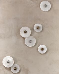 four white lights hanging from the ceiling in a room with concrete walls and flooring