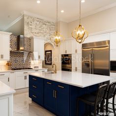 a kitchen with white cabinets and blue island