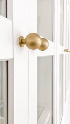 an open door with two knobs on the front and side doors in white painted wood