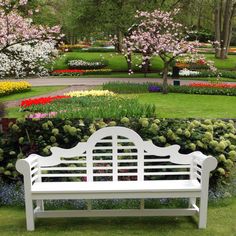 a white bench sitting in the middle of a flower garden