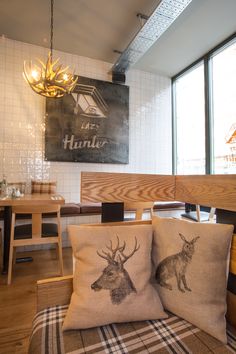 two pillows sitting on top of a couch in front of a wooden table and chairs