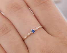 a woman's hand with a diamond and blue sapphire ring