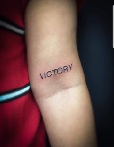 a woman's arm with the word victory tattooed on it