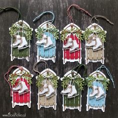 six christmas ornament hangings with snow boots and stockings in them on a wooden table