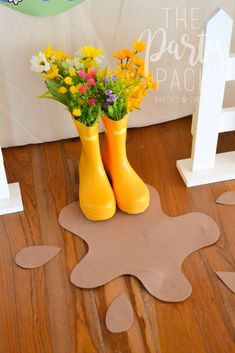 two yellow boots with flowers in them sitting on the floor