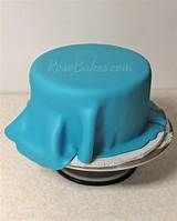 there is a blue cake on top of a silver plate with a cover over it