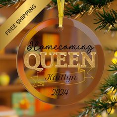 a christmas ornament hanging from a tree with the words, home coming queen written on it