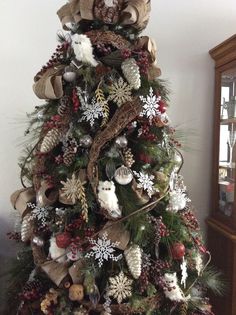 a christmas tree decorated with burlocks, pine cones and other holiday decor items