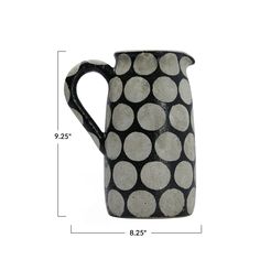 a black and white polka dot pitcher is shown with the measurements for it's size