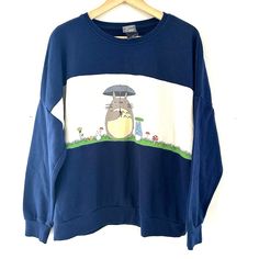 a blue sweatshirt with an image of a cartoon character on the front and back, hanging from a wooden hanger