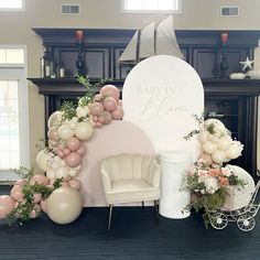 a baby's first birthday party setup with balloons and flowers on the fireplace mantel