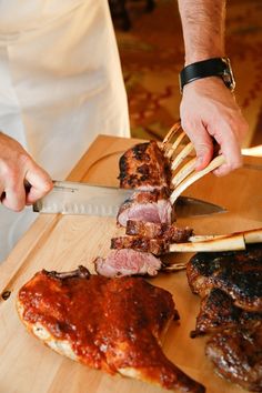 a person cutting meat on top of a wooden cutting board