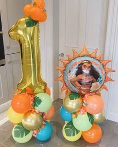 the balloon columns are decorated with oranges, blue and green balloons that spell out 1