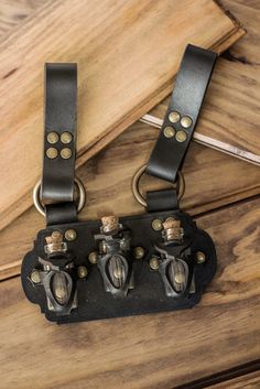 two black leather straps are attached to a wooden table