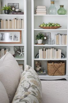 a living room filled with lots of white bookshelves and vases on top of them