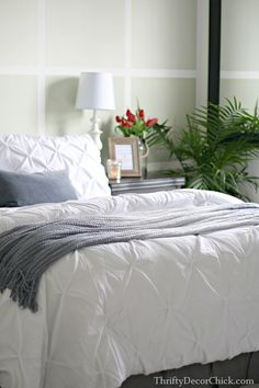 a bed with white comforter and pillows in a bedroom