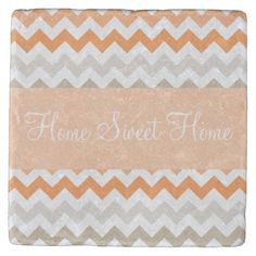 an orange and white chevroned tile with the words home sweet home