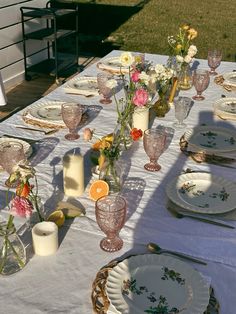 the table is set with flowers and plates