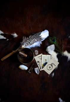 the feathers are laying on top of each other next to a spoon and some cards