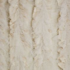 the back side of a white fur coat with ruffled edges and long fringes