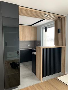 an empty kitchen and dining room with wood accents on the walls, along with black appliances