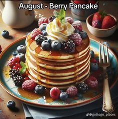 a stack of pancakes topped with whipped cream and berries