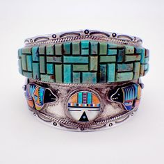 "Native American Zuni handmade massive sterling silver cuff bracelet, decorated with spectacular Turquoise maze, applied silver leaves or feathers as well as tribal Sun Face and bear figures, made of multi-colored inlaid gemstones. Borders are accented with embossed patterns and applied twisted wire rims. This incredible bracelet is 6 5/8\" long, 2 3/8\" at the widest and weighs 128.2 grams. EA2473" Turquoise Inlay Bracelet For Collectors, Southwestern Multicolor Bracelets With Inlay, Artisan Multicolor Bracelets With Inlay, Multicolor Artisan Bracelet With Inlay, Multicolor Artisan Inlay Bracelets, Artisan Multicolor Cuff Bracelet With Inlay, Artisan Multicolor Inlay Cuff Bracelet, Multicolor Handmade Cuff Bracelet Collectible, Handmade Multicolor Cuff Bracelet Collectible