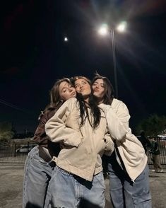 four young women standing together in front of a street light