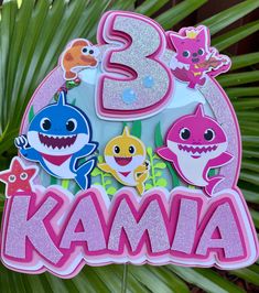 a birthday cake topper with the number three in front of some cartoon animals and sharks