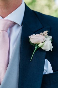 a man wearing a suit and tie with a boutonniere on his lapel