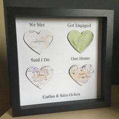 three heart shaped magnets in a black frame with the words we met got engaged and our home