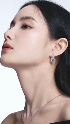 a woman wearing a necklace and earring with a flower design on the back of her head