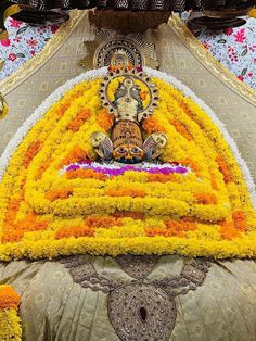 an elaborately decorated bed with flowers on the bottom and head piece in the middle