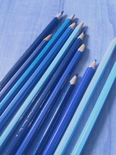 several blue and yellow pencils are lined up on a tablecloth with the same color