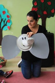 a woman sitting on the floor with a hat and an elephant shaped object in front of her