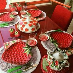 a red table topped with plates covered in strawberries