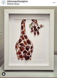 two giraffes made out of glass in a white frame